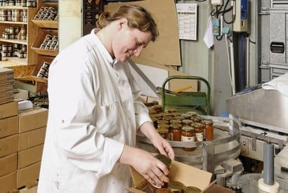 Photo d'une femme emballant un pot de confiture à l'ESAT Val de Sournia